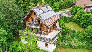 A wooden cabin with a balcony, surrounded by lush greenery. - Ferienhaus mit Ausblick (Bad Goisern am Hallstät)