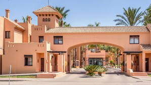 A building with a central archway, multiple windows, and a tower-like structure. - Beach front apartment in Los Alcázares (Los Alcázares)
