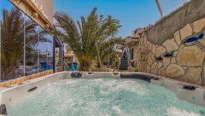 A hot tub surrounded by stone walls and palm trees. - Cozy home in Novi Vinodolski (Novi Vinodolski)