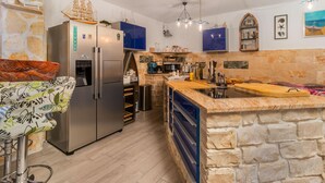 A modern kitchen with a built-in island, stainless steel appliances, and stone accents. - Cozy home in Novi Vinodolski (Novi Vinodolski)