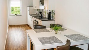 A modern kitchen with white cabinets, a black countertop, and a window with a view of greenery. - Cozy apartment in Passow OT Charlottenho (Passow OT Charlottenho)