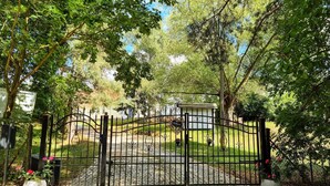 A gated entrance to a property with a cobblestone path leading to a white building. - Cozy apartment in Passow OT Charlottenho (Passow OT Charlottenho)