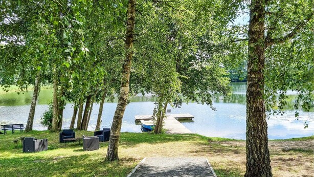 A lakeside park with a wooden dock, benches, and a picnic area. - Cozy apartment in Passow OT Charlottenho (Passow OT Charlottenho)