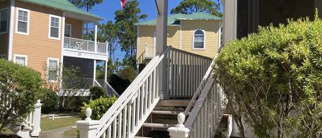 A two-story building with a porch and a flagpole with an American flag.