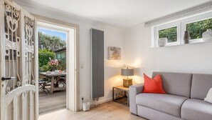 Ein Wohnzimmer mit einem grauen Sofa, einem Tisch mit einer Lampe und einer Heizung.
