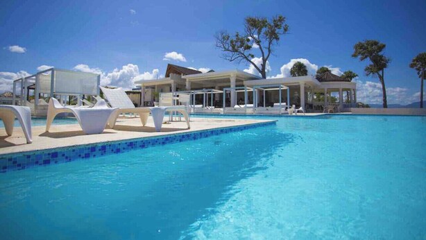 A swimming pool with lounge chairs and a gazebo. - Rilaxing villa Ocean Village (Sosua)