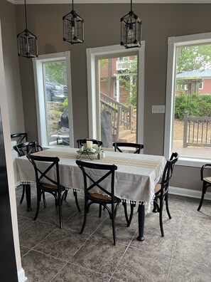 A dining area with a table set for six, surrounded by black chairs with woven seats. There are three black hanging light fixtures above the table. - Lake life at its best, Home on Ky Lake.  Amazing Sunrises! Near Moors Resort. (Gilbertsville)