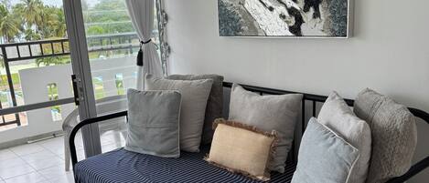 A modern living room with a sofa, pillows, a table, and a large abstract painting.