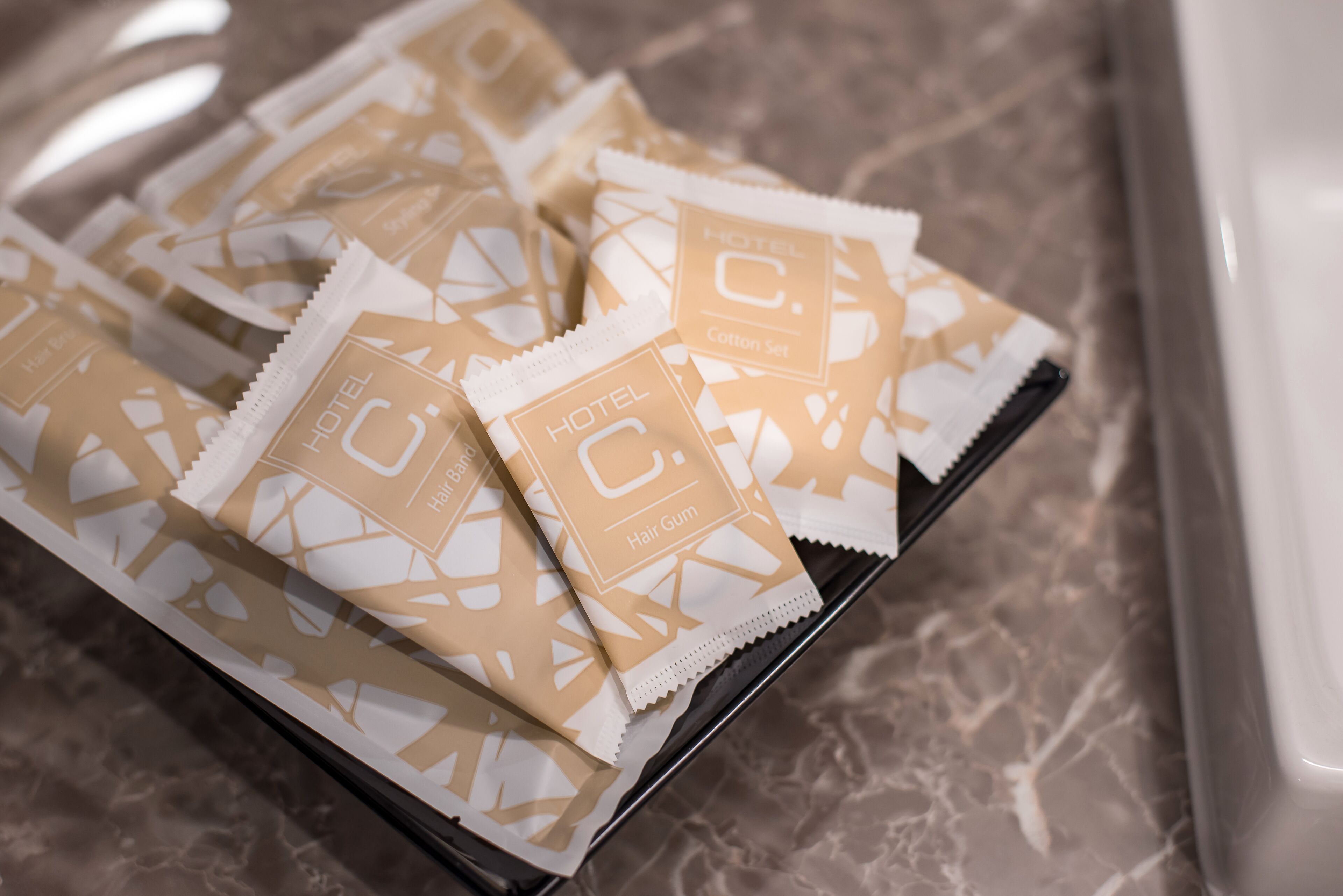 Un plateau contenant des paquets de gel coiffant de la gamme « Hotel C. Cotton Set ».