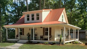 A single-story house with a gabled roof, a covered porch, and a small front yard. - Porchland Cottage -PRACTICALLY NEW HOUSE with Countryside view -pet friendly (Portland)