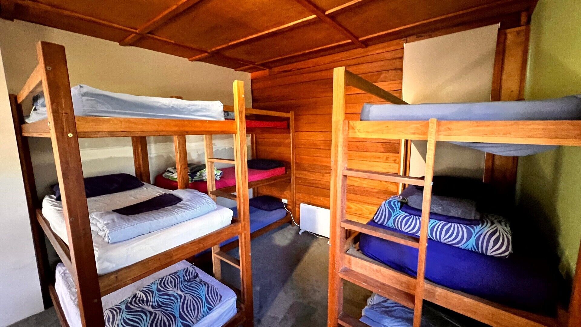 Un dormitorio con literas, paredes de madera y una ventana.