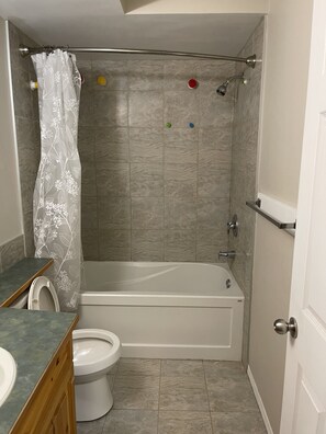 Une salle de bain équipée d’une baignoire, de toilettes et d’un espace douche.
