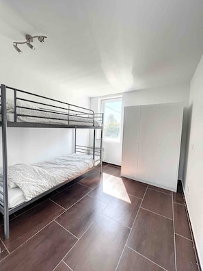A dormitory room with a bunk bed, a wardrobe, and a window providing natural light. - House With Free Parking 15min From The Airport (Charleroi)