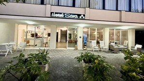 A hotel named "Hotel Sara" with a modern design, featuring a well-lit entrance, a reception area, and outdoor seating. - Hotel Sara - 2 Guests Room - n 13 (Cesenatico)