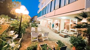 A hotel courtyard with outdoor seating and potted plants. - Hotel Sara - 2 Guests Room - n 13 (Cesenatico)