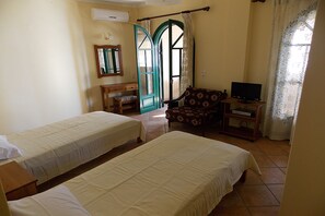 Ein Zimmer mit zwei Betten, einem Fernseher, einem Schreibtisch und einem Stuhl.