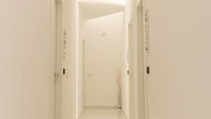 A corridor with white walls and a marble floor, leading to a door at the end. - Room in B&B - B&B Kreart Suite & Rooms (Crotone)