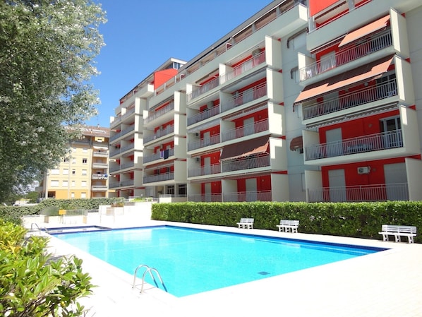 Enjoy a refreshing dip in the pool surrounded by lush greenery and comfortable lounge chairs.