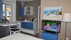 A compact room with a kitchenette, a bed, a TV, and a window. - La Bouganville Studio 200 m From the sea (Sperlonga)