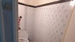 Un baño pequeño con inodoro, lavamanos y ducha.