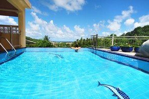 Relax by the serene pool surrounded by lush greenery.