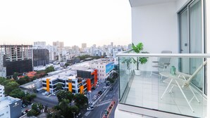 Un balcón con barandilla de cristal con vistas a la ciudad.
