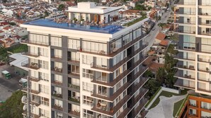 A multi-story residential building with balconies, a rooftop pool, and a parking area. - Spectacular Beach And Mountain View Condo - 5 Min From The Beach (Puerto Vallarta)
