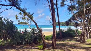 A beach with clear blue water, surrounded by trees and vegetation. - Kata Beach Ozone Superb Fully Equipped Studio Kitchen Washing Machine Aircon (Karon)