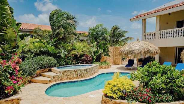 A pool area with a curved pool, stone steps, and lounge chairs.