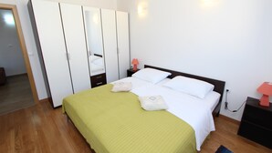 A bedroom with a bed, a wardrobe, a nightstand, and a lamp. - Hanna One-bedroom Apartment (Rovinj)