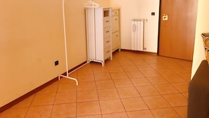 Een kamer met een witte kast, een radiator en een houten deur.