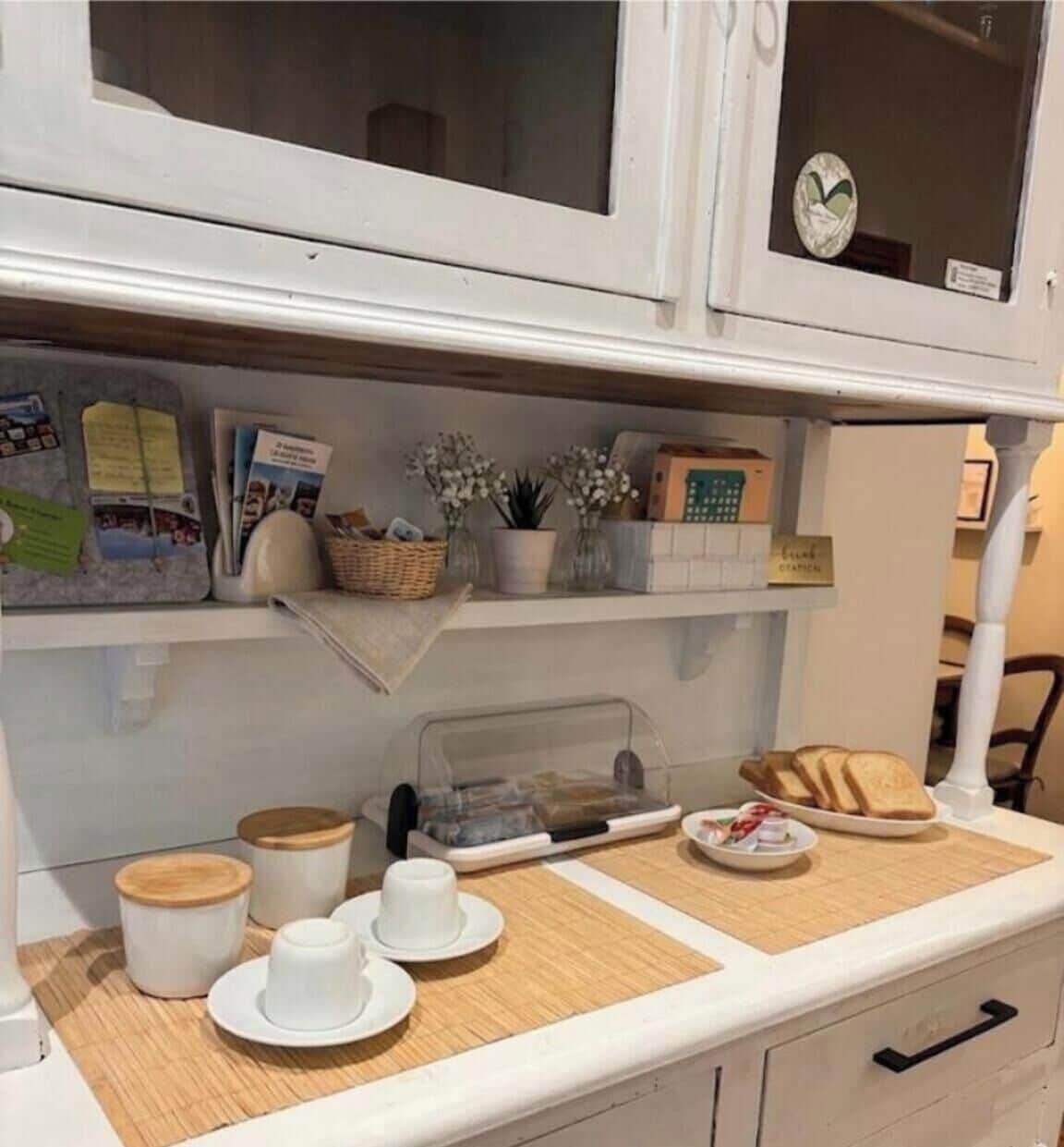 A breakfast setup with a tray, cups, and a sign indicating a 'breakfast station.'