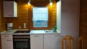 Una cocina compacta con horno integrado, cafetera y lavabo.