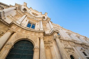 A historic building with ornate architecture, featuring a large arched doorway and detailed carvings.