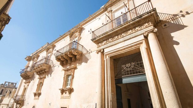 Un edificio histórico con balcones ornamentados y arquitectura clásica.