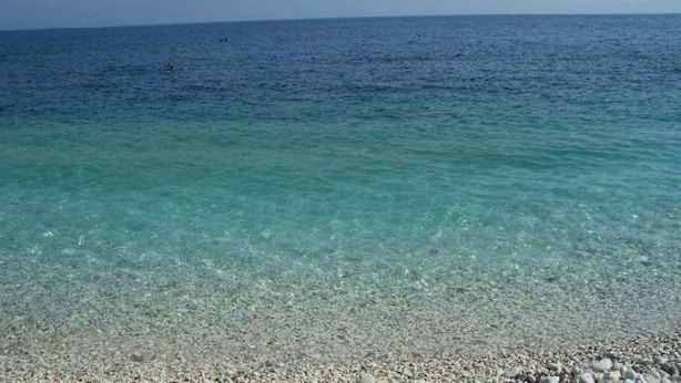 A clear view of a pebble beach leading to a calm sea. - The Harmony - Beachfront sea View Apartment (Corfu)