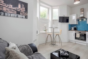 A modern apartment with a living room, dining area, and kitchen.