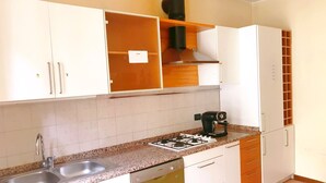 A kitchen with white cabinets, a gas stove, a coffee maker, and a dishwasher.