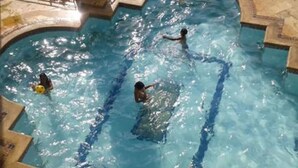 Une piscine à l’eau claire, avec des bords carrelés et un design incurvé.
