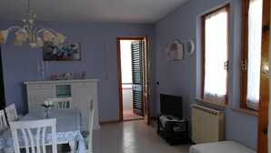 A dining area with a table and chairs, a TV, and a sofa. - Casa Annick Holiday Home (Barberino Tavarnelle)