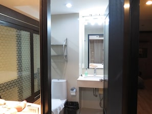 A bathroom with a toilet, sink, and shower.