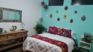 Un dormitorio con una cama, un aparador, un espejo y decoración en la pared.