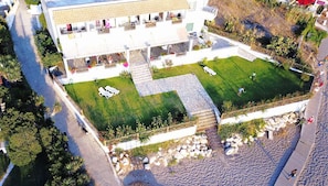 A modern building with a courtyard, outdoor seating, and a pool area.