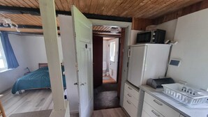 A compact room with a bed, a kitchenette, and a bathroom. - A Cozy House to Stay in Vandel (Vandel)