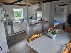 A modern kitchen with a dining area, a small island, and a window. - A Cozy House to Stay in Vandel (Vandel)