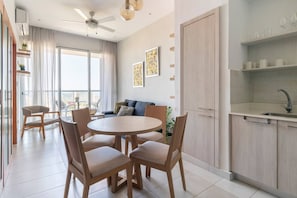 A modern living room with a round table and chairs, a sofa, and a balcony with a view. - Apartamento S1404 - Downtown Santo Domingo (Santo Domingo)