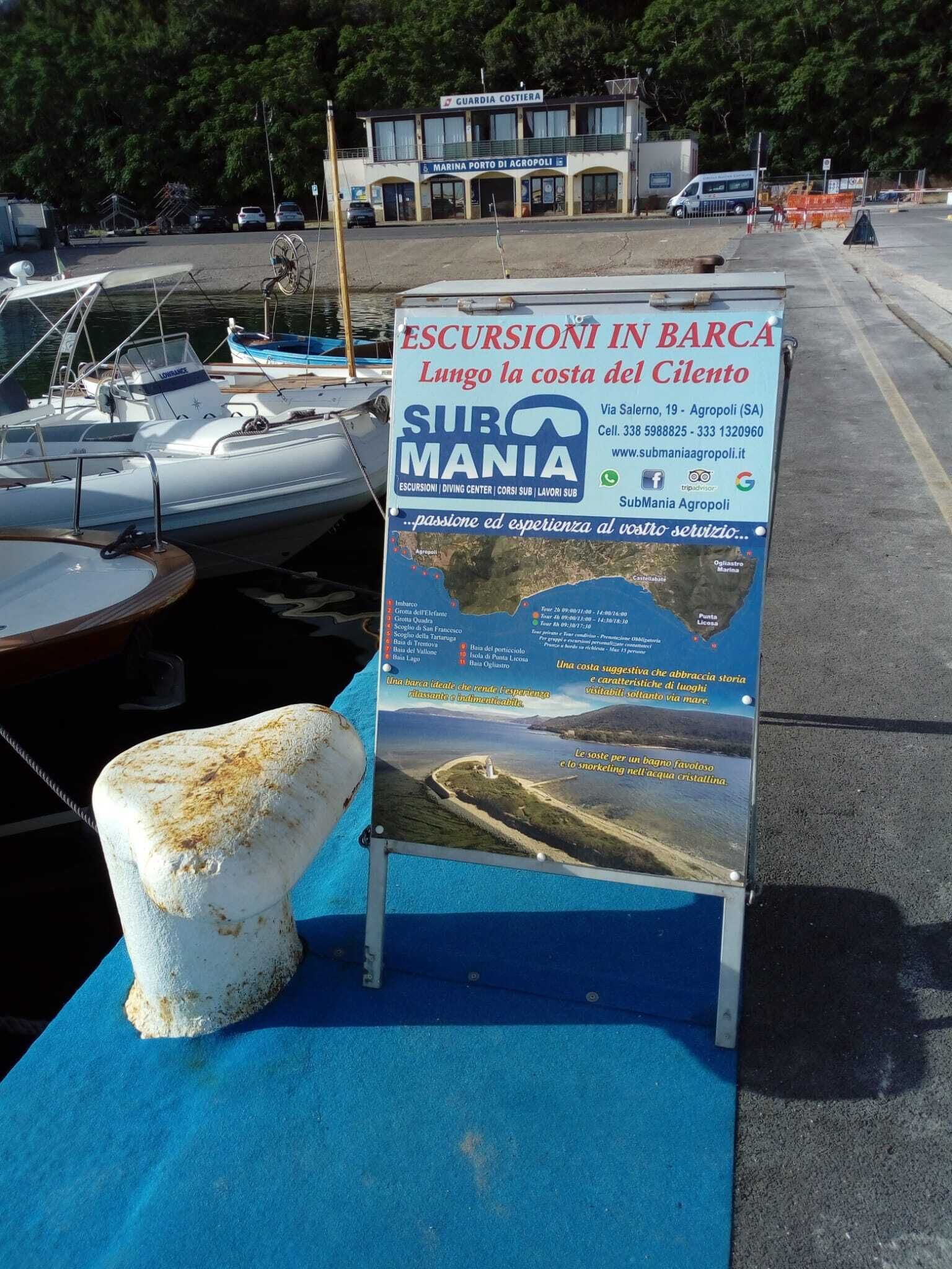 Ein Schild für SubMania in Agropoli mit Angaben zu Bootsausflügen und Kontaktinformationen.
