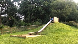 A playground with a slide and a small wooden structure. - Nuthatch Lodge is set in 24 Acres of Wood, Parkland Near the Village of Cenarth (Newcastle Emlyn)
