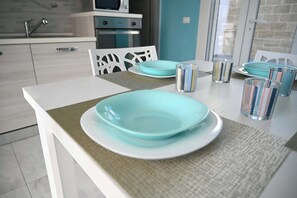 Une cuisine moderne avec des meubles blancs, un four à micro-ondes et un évier.