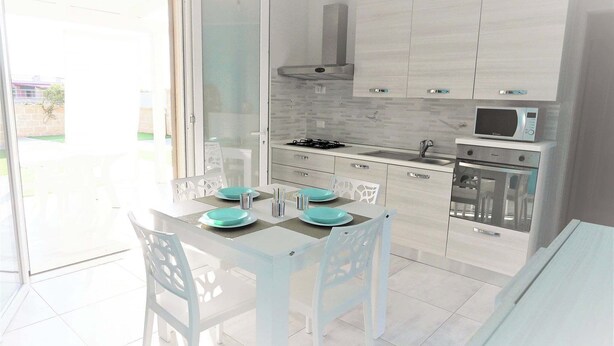 A modern kitchen with white cabinets, a microwave, and a gas stove. - Villa Noire 'just 900mt From The Crystalline Waters Of Salento (Nardò)